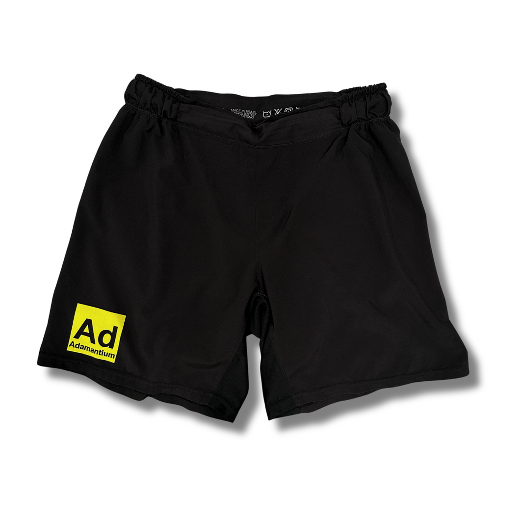 Black Adamantium BJJ fight shorts with yellow logo on the front left leg.