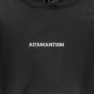 Close-up of the Adamantium BJJ black hoodie featuring minimalist logo detail.
